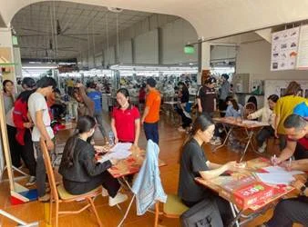 A group of people sitting at tables in a roomAI-generated content may be incorrect.