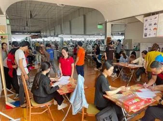 A group of people sitting at tables in a roomAI-generated content may be incorrect.